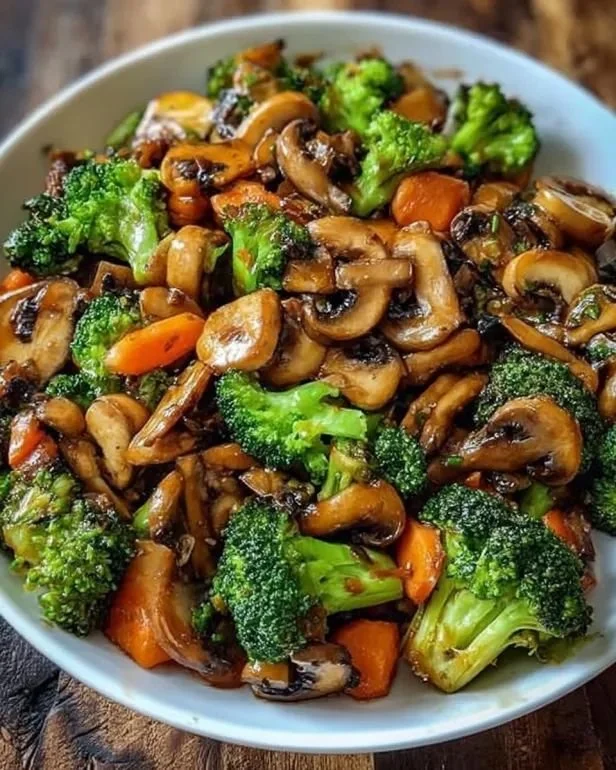 15-Minuten-Pfanne mit Champignons, Brokkoli und Karotten auf einem Teller.