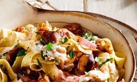 Cremige Maronen-Pappardelle mit Pilzen und Parmesan auf einem Teller angerichtet