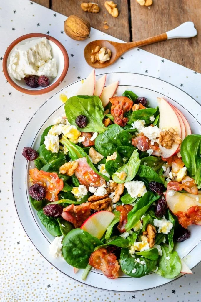 Feldsalat mit Speck, Walnüssen und Äpfeln auf einem Teller