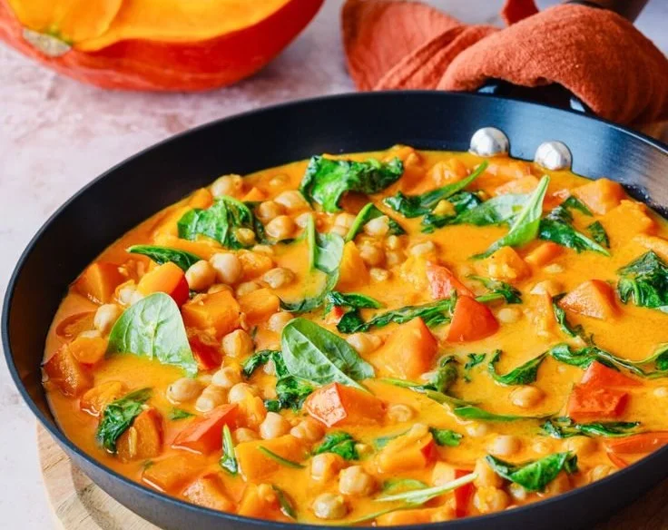 Leckeres Kürbis Curry mit Kichererbsen serviert in einer bunten Schüssel