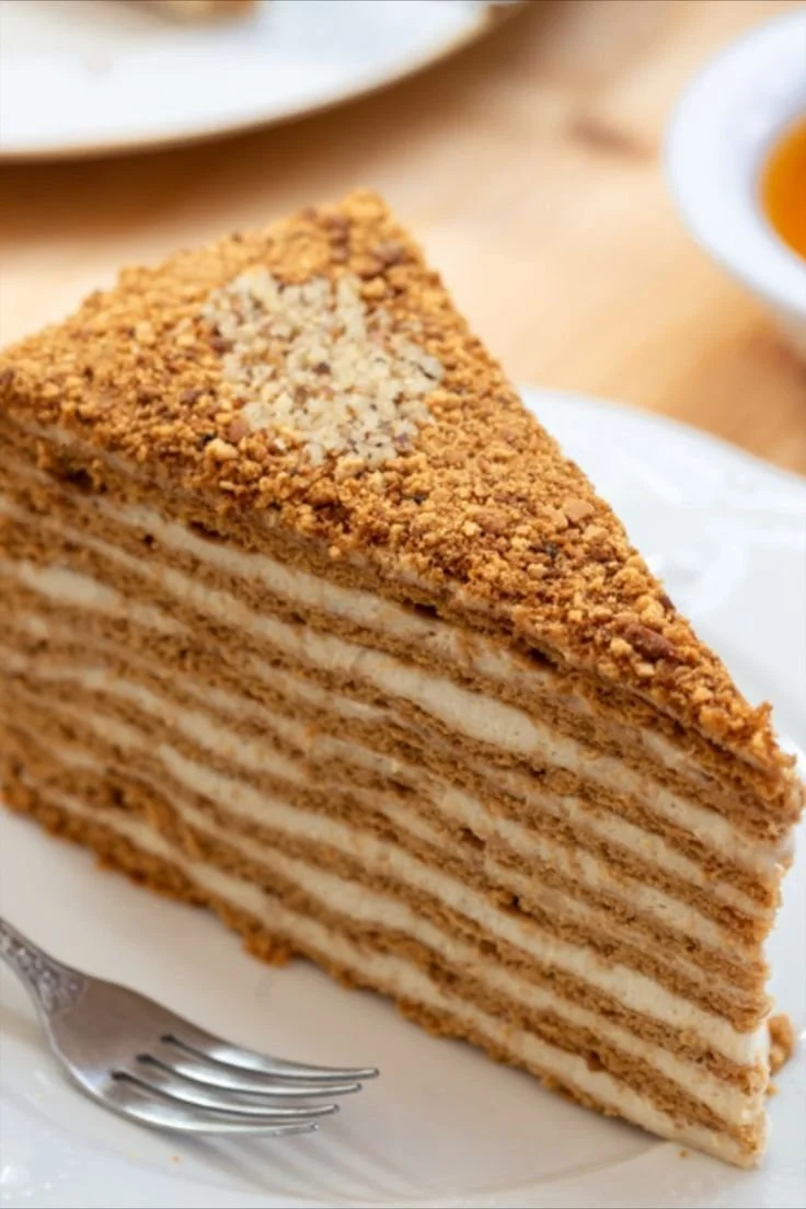 Russische Honigtorte mit Schmandcreme auf einem eleganten Teller dekoriert