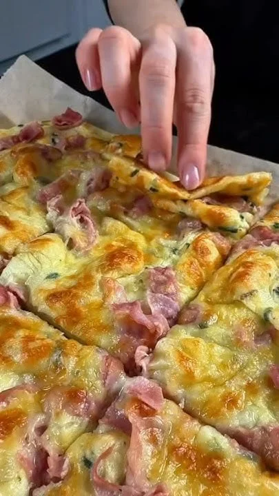 Schinken-Käse-Pfannkuchen aus dem Ofen auf einem Teller, serviert mit frischen Kräutern